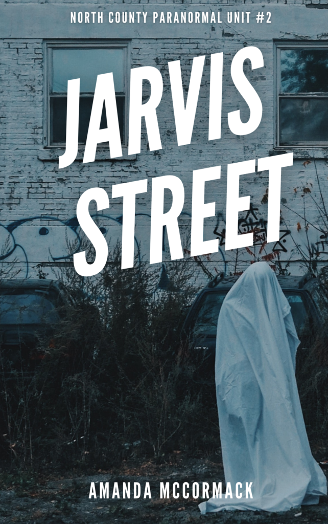 A person in a ghost costume is walking past an old white building covered in graffiti. The ghost is slouching as it walks and the entire scene is tinted a cold blue. Text above the ghost reads Jarvis Street